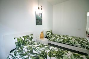 een slaapkamer met 2 bedden met groene bladeren bij Casa Salazar in Fuencaliente de la Palma