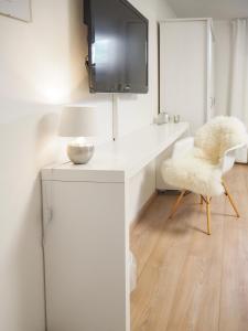 a white desk with a lamp and a chair at Stylische Wohnung in ruhiger Lage, sehr messenah in Laatzen