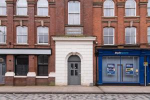 a brick building with a blue door on a street at Sublime Stays Webberley Stylish Studio Stoke City Centre in Stoke on Trent