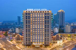 a large building with a sign on the top of it at Atour Hotel Ningbo Fenghua Huizheng Street in Ningbo