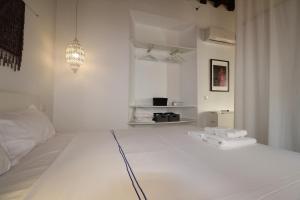 biała sypialnia z ręcznikami na łóżku w obiekcie Del Parque Flats Alvarez Suite w Maladze