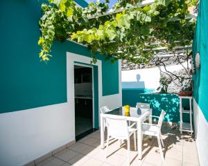 eine Terrasse mit einem Tisch und Stühlen sowie einer blauen Wand in der Unterkunft Casa Salazar in Fuencaliente de la Palma