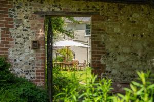 una puerta abierta a un patio con sombrilla en Henge Estate - Restored Manor House, up to 11 en-suite bedrooms, en Shrewton