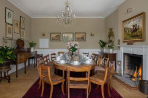 a dining room with a table and chairs and a fireplace at Henge Estate - Restored Manor House, up to 11 en-suite bedrooms in Shrewton