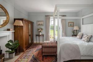 a bedroom with a white bed and a mirror at Shrewton House - Stunning 4 double ensuite bedrooms in Shrewton