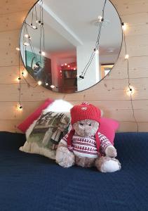um urso de peluche sentado numa cama num quarto em Nérine em Leysin