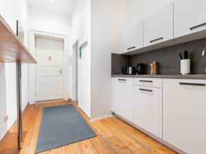 a kitchen with white cabinets and white appliances at limehome Berlin Malmöer Straße in Berlin