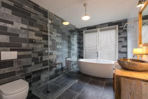 a bathroom with a tub and a sink at Welcome in - Lepelstraat 14, Vrouwenpolder- Knotwilg in Vrouwenpolder +47 photos