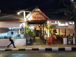 a man walking past a restaurant at night at Palm Grove 1 Bhk Apartment at Candolim Beach with free Wifi in Candolim