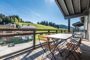 a patio with a table and chairs on a deck at Apartment Merbau Les Gets - by EMERALD STAY in Les Gets
