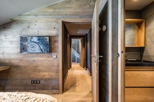 a hallway leading to the kitchen in a log house at Apartment Merbau Les Gets - by EMERALD STAY in Les Gets