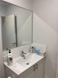 a bathroom with a sink and a large mirror at Chic 2Bed Close Airport Shops NETFLIX WIFI WINE in Perth