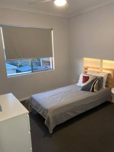 a bedroom with a bed and a window at Chic 2Bed Close Airport Shops NETFLIX WIFI WINE in Perth