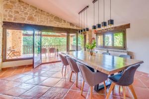 - une salle à manger avec une table et des chaises en bois dans l'établissement Masia Ventanell Luxury villa near Barcelona, à Llacuna