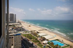 a view of the beach and ocean from a building at Apartments4you Leonardo 11 in Bat Yam