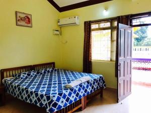 a bedroom with a bed with a blue and white at Lobo's Guesthouse in Cavelossim