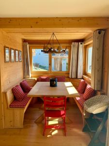 uma sala de jantar com uma mesa de madeira e cadeiras vermelhas em K2 Chalet em Crans-Montana