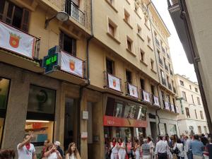 un grupo de personas caminando por una calle frente a un edificio en Hostal Cristina, en Estella