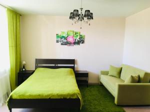 カザンにあるWasabi Apartmentのベッドルーム(緑のベッド1台、ソファ付)