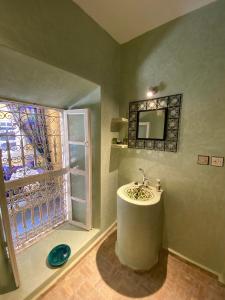 a bathroom with a sink and a window at Riad Hotel Sherazade in Marrakech