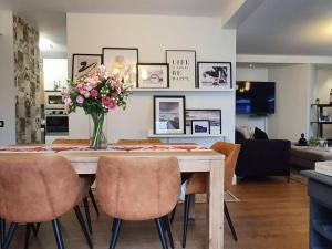 ダーバンにあるLuxury Apartment in Umhlanga Rocksの椅子と花瓶が置かれたダイニングテーブル