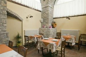 a restaurant with tables and chairs and a stone pillar at La Campana D'Oro in Beverino