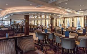 KD Hotelship Düsseldorf Comfort Plus في دوسلدورف: مطعم على سفينة الرحلات البحرية مع طاولات وكراسي