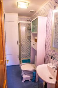 y baño con ducha, aseo y lavamanos. en Green Suites Miengo - Apto Completo en Miengo
