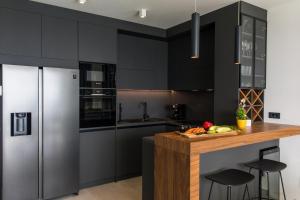 cocina con armarios negros y encimera de madera en Luxury Villa Helios 5*, en Dubrovnik