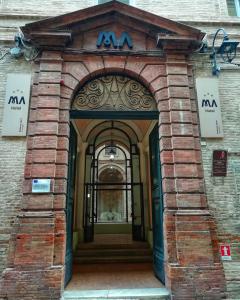 un accès à un bâtiment avec une arche dans l'établissement MA Hotel, à Corinaldo