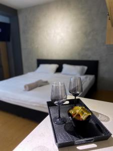 a table with two wine glasses and a tray with snacks at MT Apartments Skopje in Skopje
