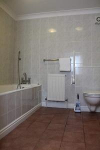 een badkamer met een bad, een toilet en een wastafel bij The Sportsman Chalets in Kent