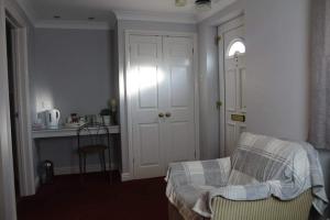 a room with a door and a chair and a kitchen at The Sportsman Chalets in Kent