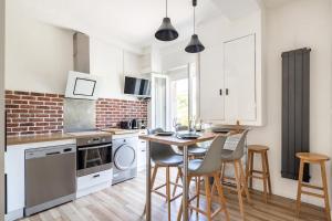 a kitchen with white cabinets and a table and chairs at Superbe appartement dans le centre historique in Poitiers