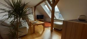 a living room with a staircase with a table and a tv at Ferienwohnung Vor den Toren Lübecks in Herrnburg