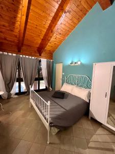 La Casa delle Favole في فوسّانو: غرفة نوم بسرير وسقف خشبي