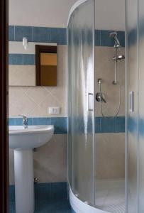 y baño con ducha y lavamanos. en Il Borgo Appartamenti, en Olbia