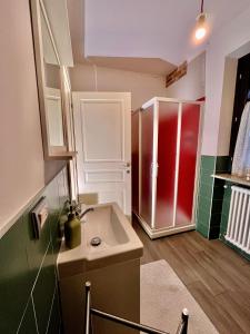 a bathroom with a sink and a red refrigerator at La Casa delle Favole in Fossano