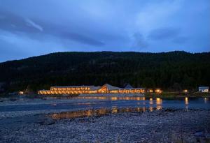 a large building with lights in the water at night at Sorrisniva Arctic Wilderness Lodge in Alta