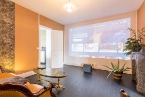 a room with a projection screen and a table and chairs at L'étoile et le Merveilleux 2 appartements SPA in Dijon