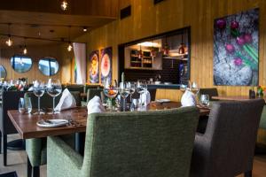 a restaurant with a wooden table with wine glasses at Sorrisniva Arctic Wilderness Lodge in Alta