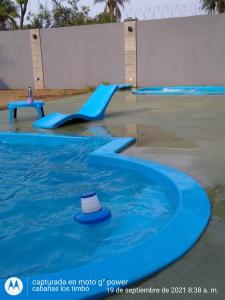 a blue water slide in a pool with a hat at Cabañas Los Timbó in Ituzaingó