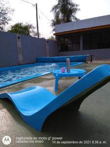 een binnenzwembad met een blauwe glijbaan naast een zwembad bij Cabañas Los Timbó in Ituzaingó