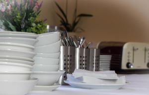 uma pilha de pratos brancos e tigelas sobre uma mesa em Preston Hotel em Yeovil