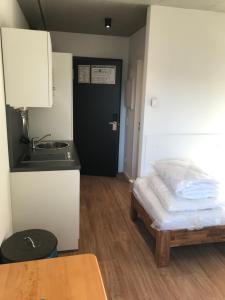 a small kitchen with a bed and a black door at SITE.INN Hamburg in Hamburg
