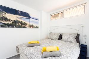 a white bedroom with a bed with yellow pillows at Apartment Royal Sunset Loggia in Palm-Mar