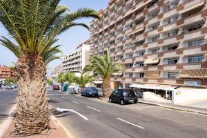a street with palm trees and a large building at Apartment Royal Sunset Loggia in Palm-Mar