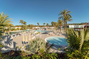 a view of a resort with a swimming pool and palm trees at Hotel LIVVO Dunagolf Suites in Maspalomas