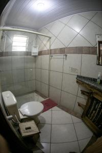 a bathroom with a toilet and a shower at Pousada Pé na Areia in Garopaba