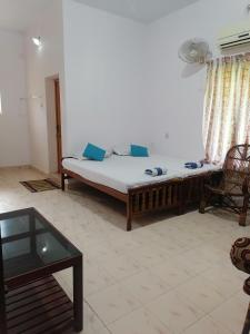 Habitación con cama y mesa. en Basuri Beach Resort, en Varkala
